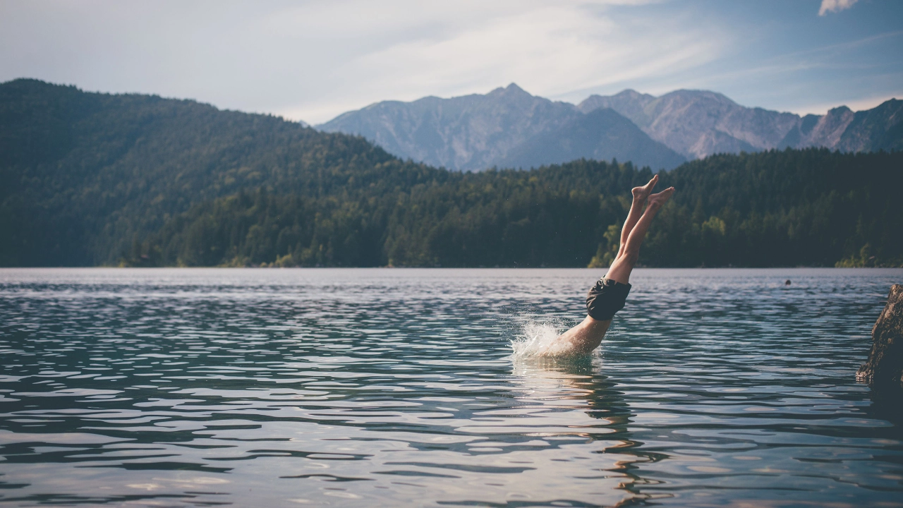 Mann springt kopfüber in einen See