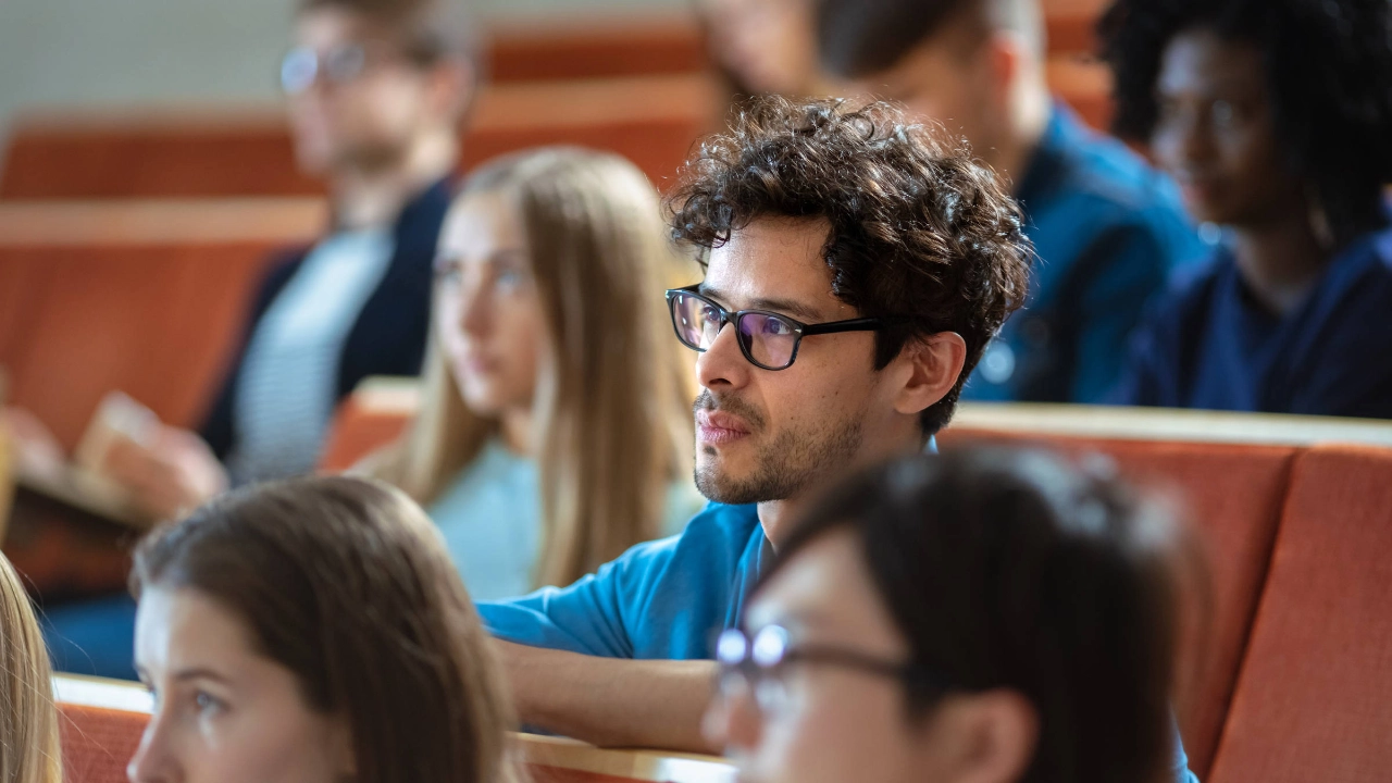 Ein junger Mann sitzt in einer Vorlesung.