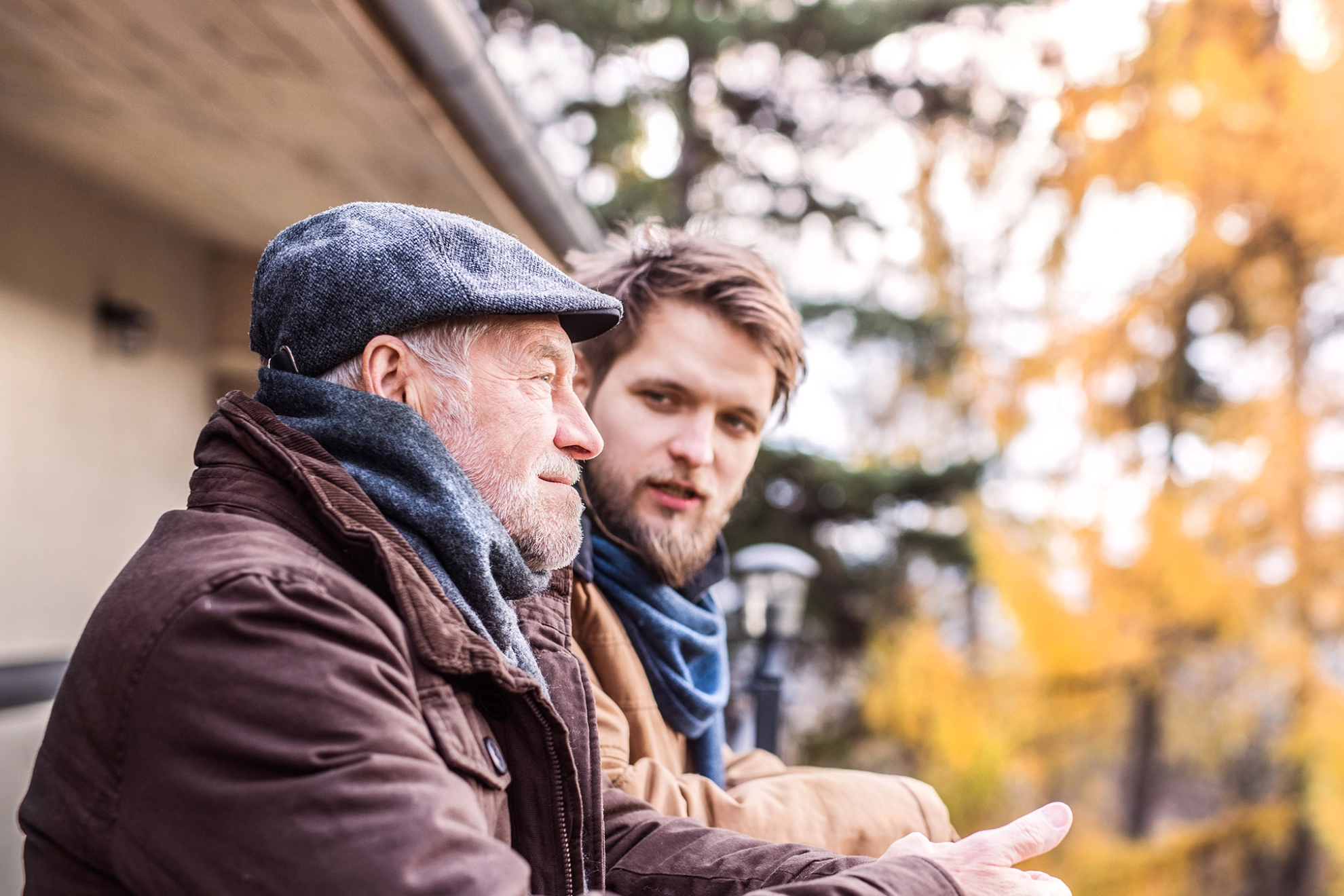 Vater und Sohn genießen zusammen den schönen Herbsttag auf dem Balkon